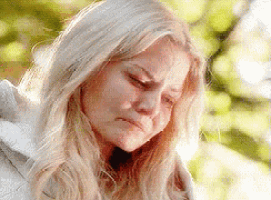 a close up of a woman 's face with her eyes closed and a sad look on her face .