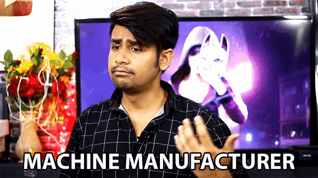 a man in a plaid shirt says machine manufacturer in front of a tv screen