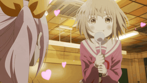 a girl in a pink shirt is holding a microphone with hearts flying around her