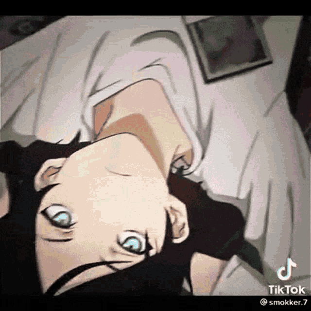 a person is laying on a bed with their head upside down and their eyes closed .