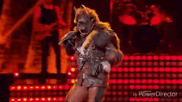 a werewolf is holding a microphone on a stage .