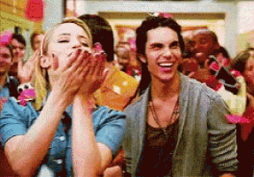 a man and a woman are laughing in front of a crowd of people