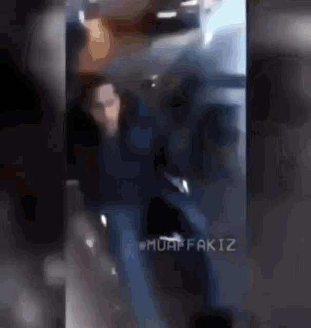a blurry picture of a man standing in a dark room with a caption that says " muhaffakiz "