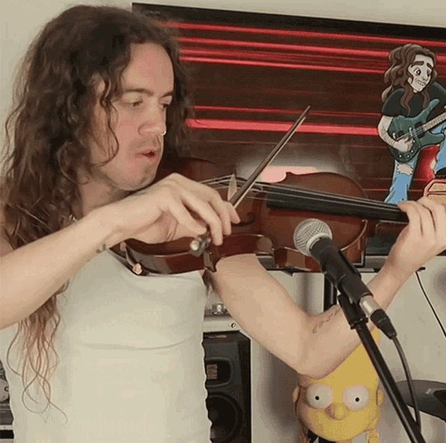 a man playing a violin in front of a microphone