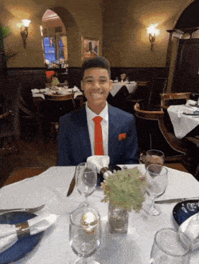 a man in a suit and tie sits at a table
