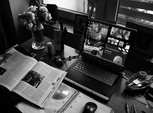 a black and white photo of a desk with a laptop open to a page that says mission