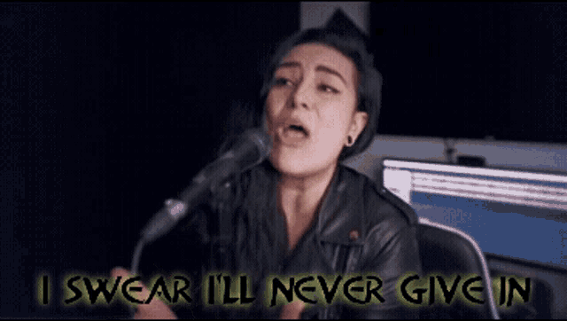 a woman singing into a microphone with the words i swear i 'll never give in behind her