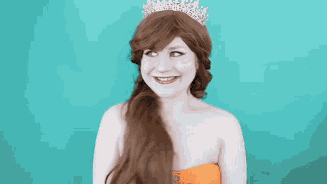 a woman wearing a tiara and a wig smiles for the camera