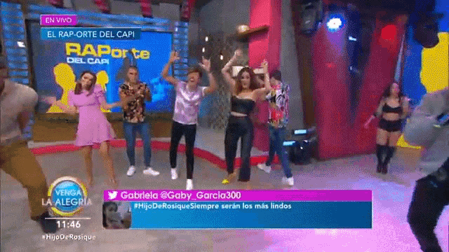 a group of people are dancing in front of a sign that says el rap orte del capi