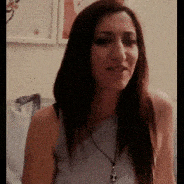 a woman with long hair is wearing a necklace