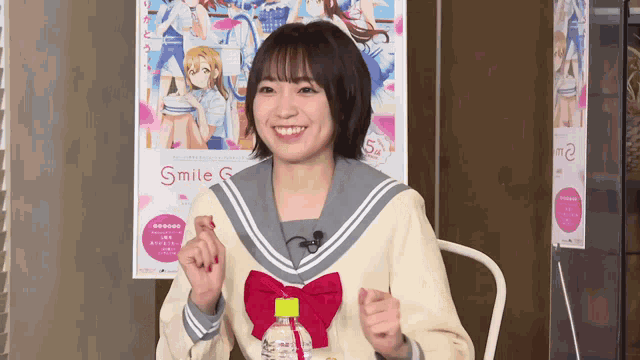 a girl is sitting in front of a poster that says smile