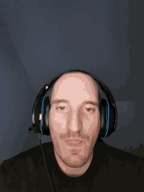 a man with a beard wearing a pair of headphones with a microphone