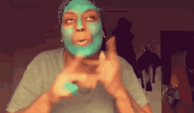 a woman with a blue mask on her face is giving the middle finger
