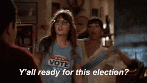 a woman wearing a t-shirt that says `` vote '' is talking to a man and another woman .
