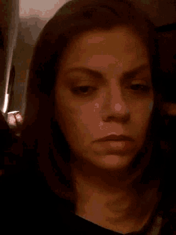 a close up of a woman 's face with a serious look on her face
