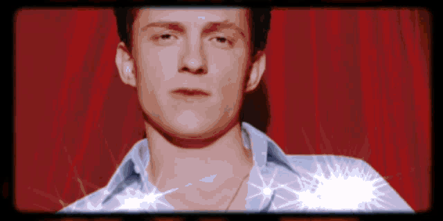 a close up of a man 's face against a red curtain