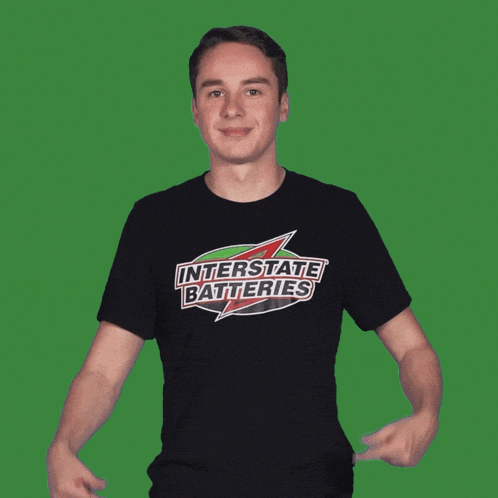a man wearing an interstate batteries t-shirt points to his chest