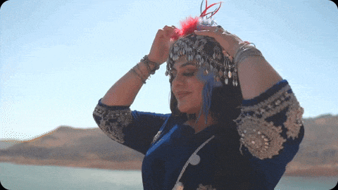 a woman wearing a blue and gold outfit and a feathered headpiece