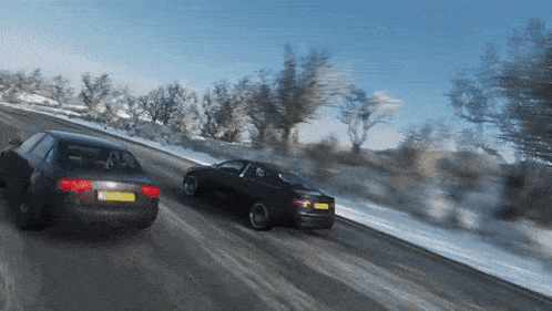 two cars are driving down a snowy road with one having a license plate that says ' aa '