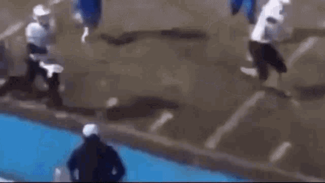 a group of people are standing in front of a pool of water .