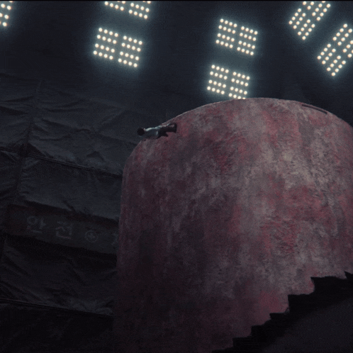 a person is standing in front of a large red sphere with the number 16 on it