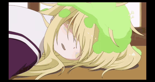 a girl with blonde hair and a green hat is laying on the floor