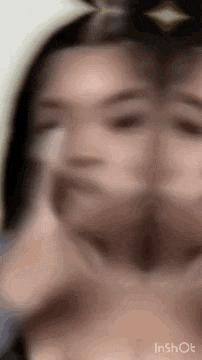 a close up of a woman 's face with a blurred background .