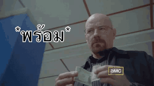 a man holding a piece of paper with a sticker that says amc