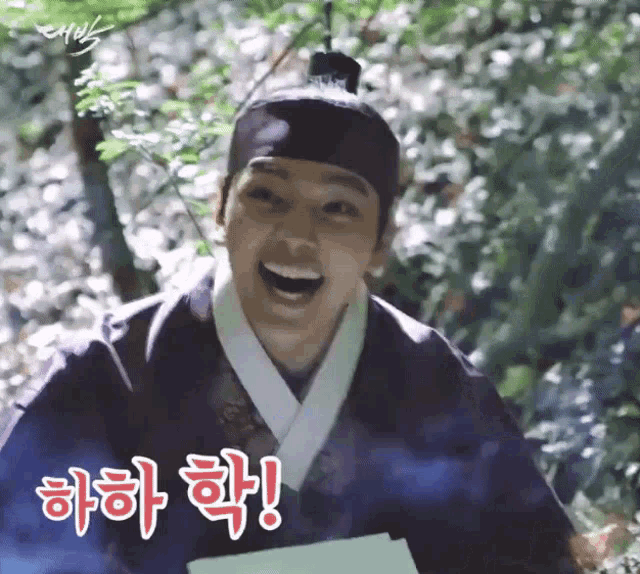 a man in a kimono is laughing and holding a piece of paper in his hand