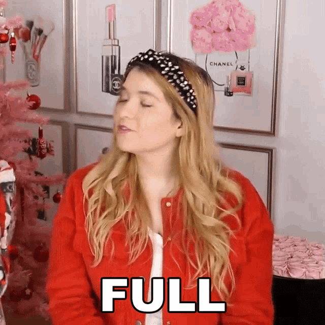 a woman in a red jacket says full in front of a christmas tree