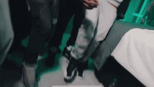 a group of people are standing around a bed in a dark room .
