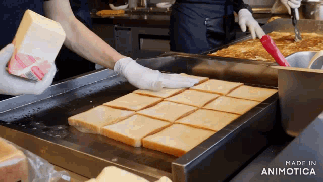a person is putting cheese on a tray of bread that is made in animotica