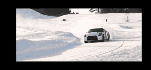 a car is driving on a snowy road with the letter p on the side
