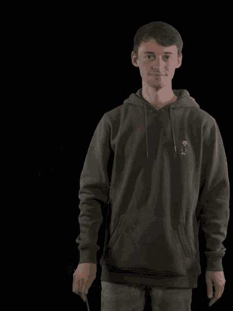 a man in a hoodie holds a rose in his mouth with a smiley face on it