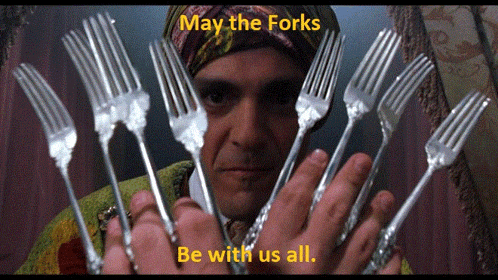 a man holding a bunch of forks with the words " may the forks be with us all " above him
