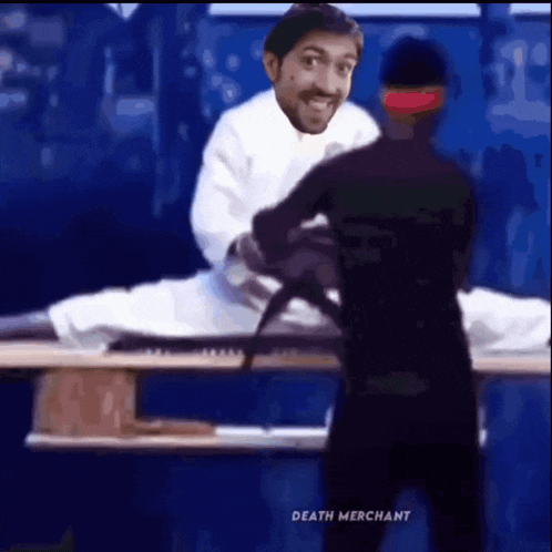 a man in a white shirt is standing next to a dead body .