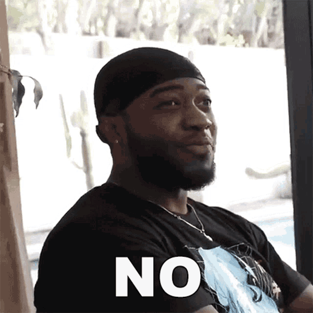 a man with a beard is wearing a black shirt that says no on it