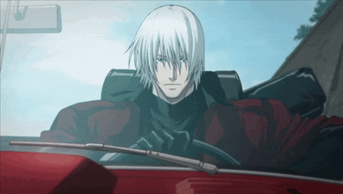 a man with long white hair is sitting in a red car