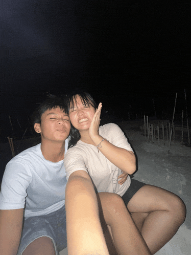 a boy and a girl are posing for a picture and the girl is smiling