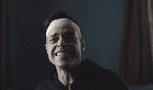 a man with a bandage on his head is laughing .