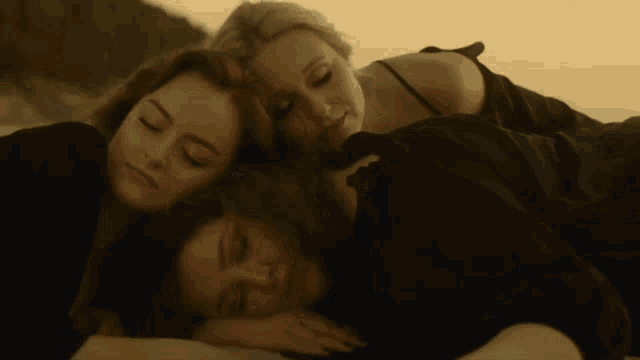 three women laying on top of each other with their heads on each other 's shoulders