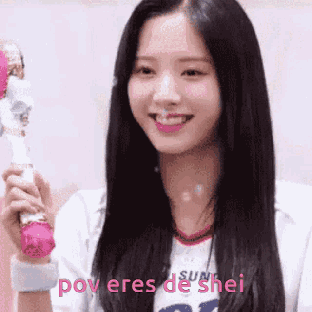 a girl with long black hair is holding a pink wand and smiling with the words pov eres de shei below her