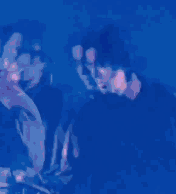 a blurry picture of two people standing next to each other in a dark room .
