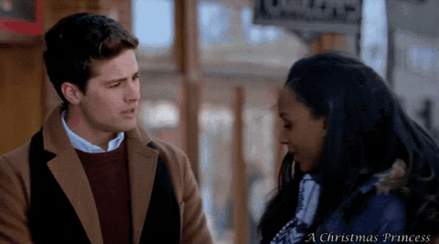 a man and a woman are looking at each other in a christmas princess movie