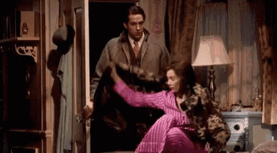 a man and a woman are fighting in a room in a movie .