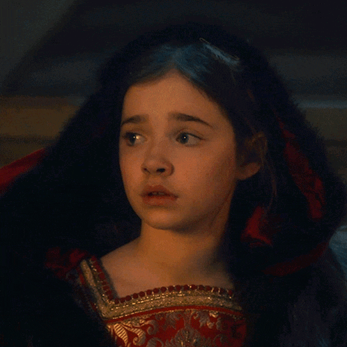 a girl with her eyes closed wearing a red dress