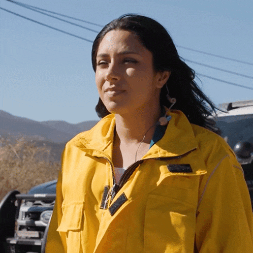 a woman wearing a yellow jacket has a sticker on her jacket that says ' abercrombie & fitch ' on it