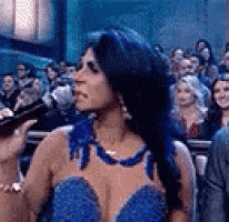 a woman wearing a blue dress is standing in front of a crowd .