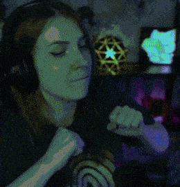 a woman wearing headphones and a rainbow shirt is making a face