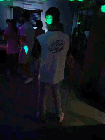 a man wearing a shirt that says ' chicago ' on it is standing in a dark room